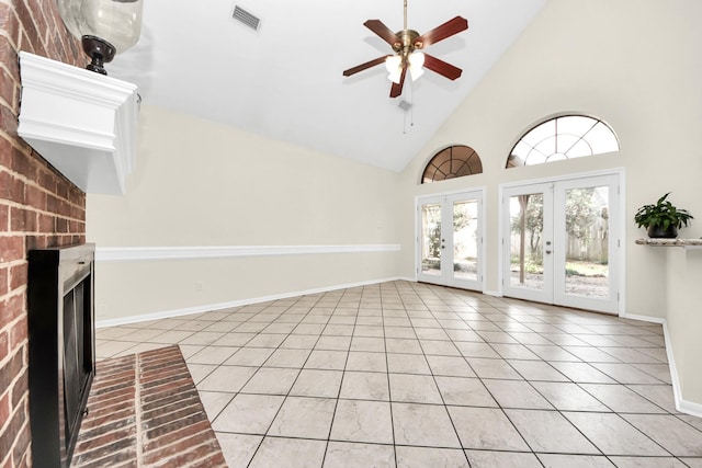 unfurnished living room with a brick fireplace, light tile patterned floors, french doors, and visible vents