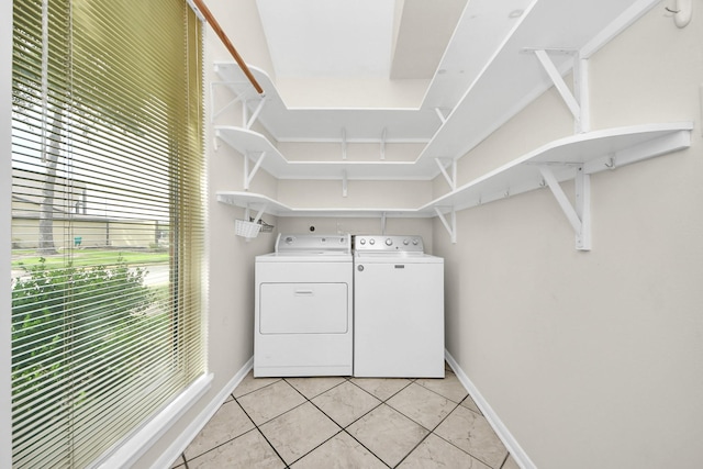 laundry area with light tile patterned flooring, laundry area, independent washer and dryer, and baseboards