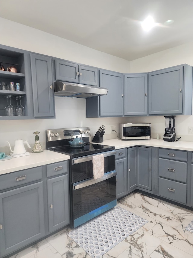 kitchen featuring under cabinet range hood, light countertops, marble finish floor, and appliances with stainless steel finishes