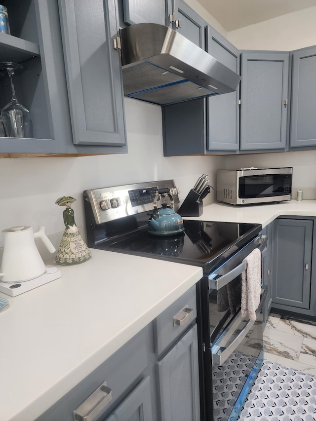 kitchen with ventilation hood, gray cabinets, stainless steel appliances, light countertops, and marble finish floor