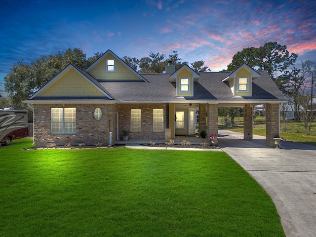 craftsman house with a yard, a chimney, brick siding, and a shingled roof