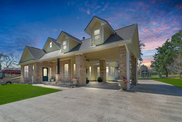 view of front of house featuring aphalt driveway, a front lawn, and a shingled roof