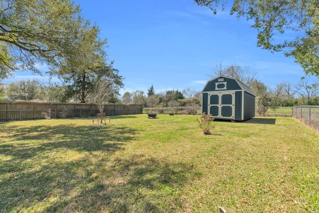 view of yard with a storage unit, an outbuilding, and a fenced backyard