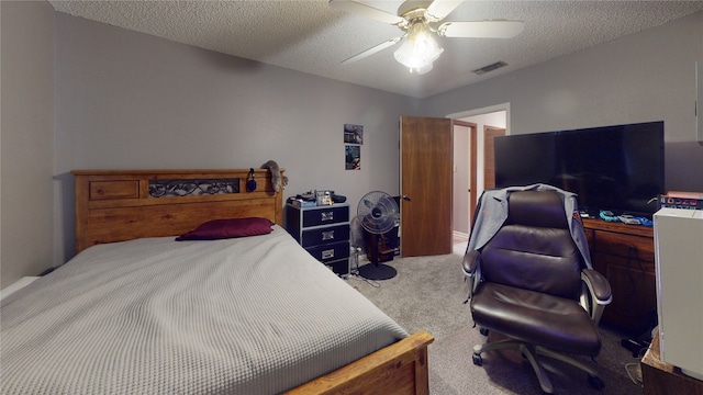 carpeted bedroom with visible vents, a textured ceiling, and a ceiling fan