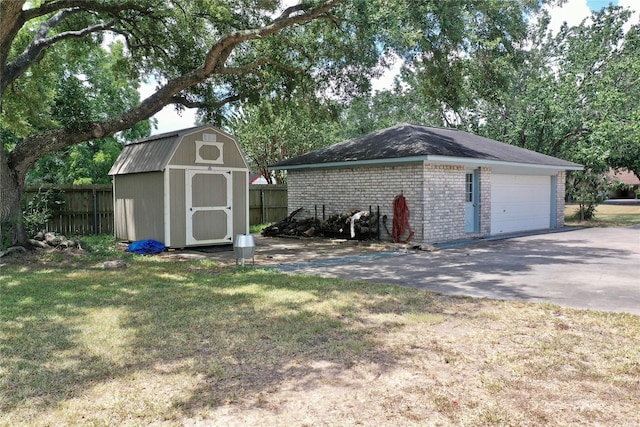 view of shed with a garage and fence