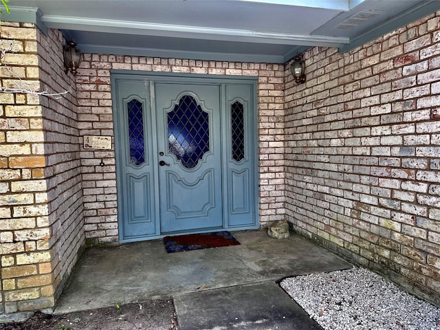 doorway to property featuring brick siding