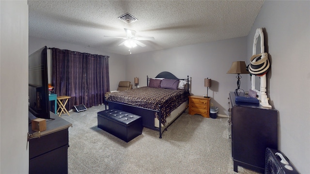 carpeted bedroom with visible vents, a textured ceiling, and ceiling fan