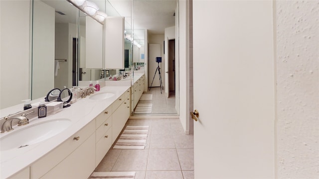 full bath featuring tile patterned flooring, double vanity, and a sink