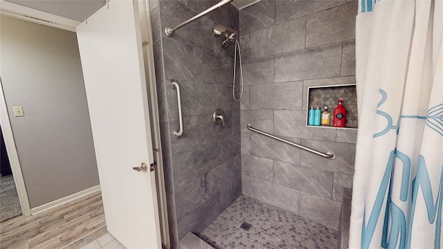 full bath featuring baseboards and a tile shower