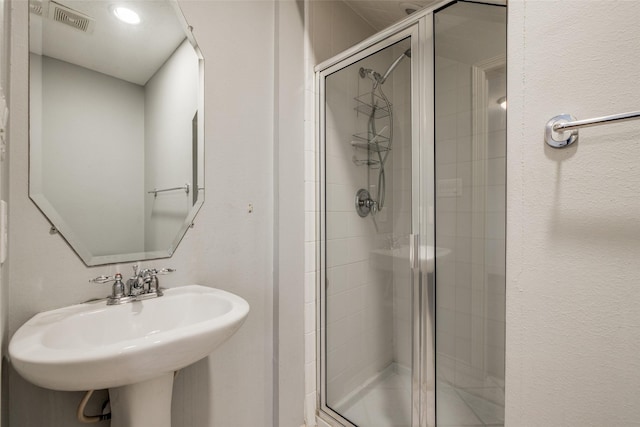 full bath featuring visible vents, a stall shower, and a sink