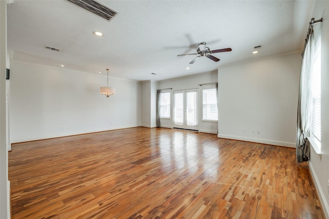 interior space with light wood finished floors, visible vents, and ornamental molding