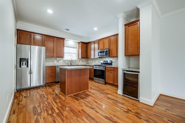 kitchen with decorative backsplash, wine cooler, light wood-style flooring, and stainless steel appliances