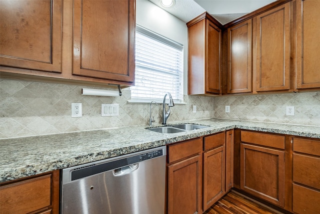 kitchen featuring a sink, light stone counters, dishwasher, and brown cabinetry