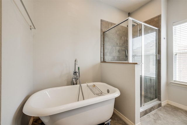 full bathroom with a shower stall, a freestanding tub, and a healthy amount of sunlight