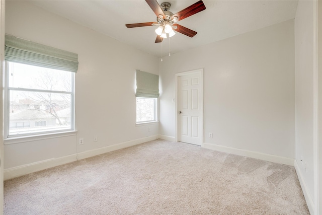 unfurnished room with baseboards, light colored carpet, and ceiling fan