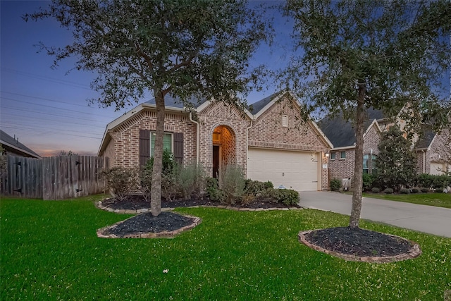 view of front of property with brick siding, a front lawn, fence, concrete driveway, and a garage