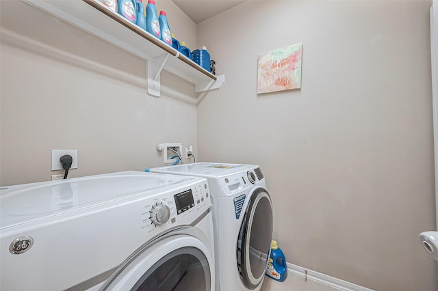 laundry area featuring baseboards, independent washer and dryer, and laundry area