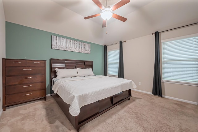 bedroom featuring light carpet, multiple windows, baseboards, and vaulted ceiling