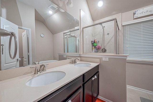 bathroom featuring a sink, lofted ceiling, double vanity, and a shower stall