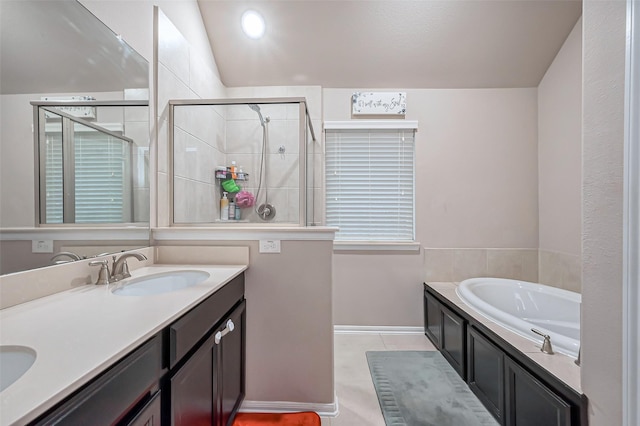 bathroom featuring double vanity, a stall shower, a sink, tile patterned flooring, and a bath