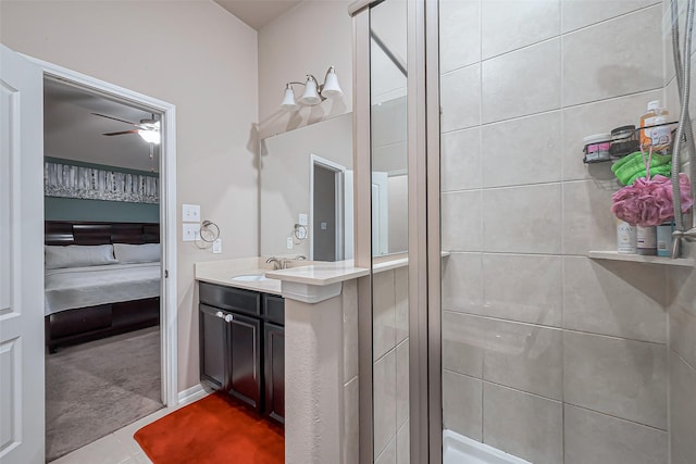 ensuite bathroom with tile patterned floors, connected bathroom, tiled shower, ceiling fan, and vanity