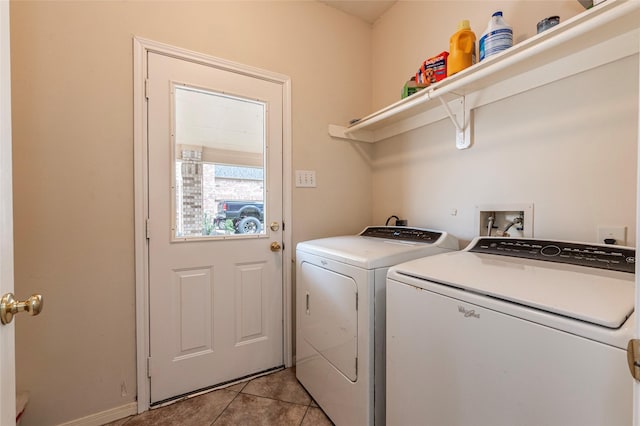 clothes washing area featuring light tile patterned floors, independent washer and dryer, and laundry area