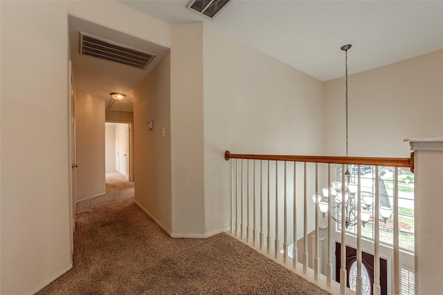 corridor featuring visible vents, baseboards, and carpet