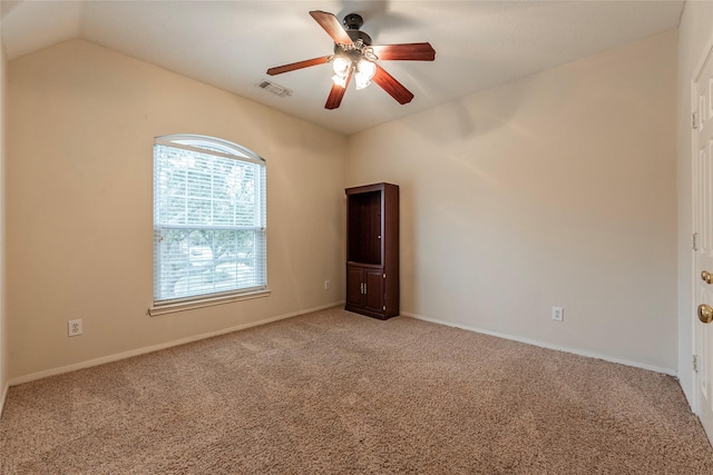 spare room featuring baseboards, visible vents, carpet floors, lofted ceiling, and ceiling fan