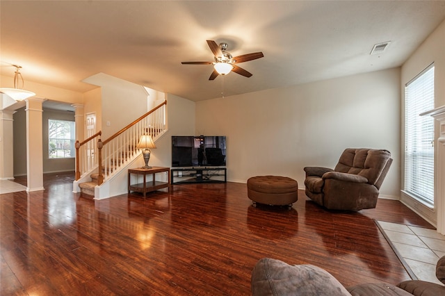 interior space with visible vents, wood finished floors, ceiling fan, stairs, and ornate columns