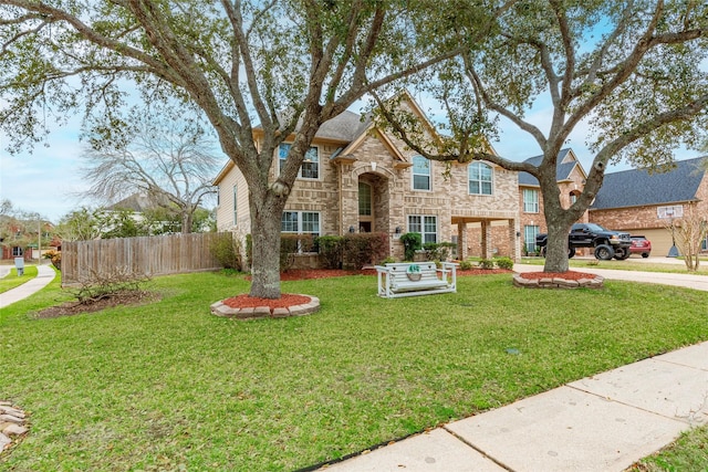 traditional home featuring a front lawn, fence, and stone siding