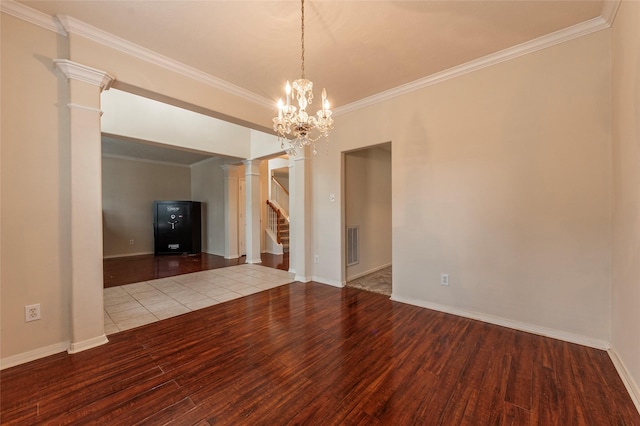 unfurnished living room with ornamental molding, wood finished floors, stairs, and decorative columns