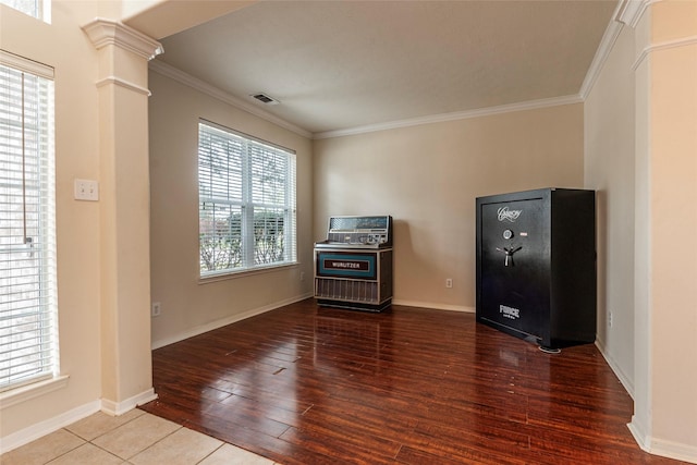 interior space with visible vents, baseboards, ornamental molding, decorative columns, and wood finished floors