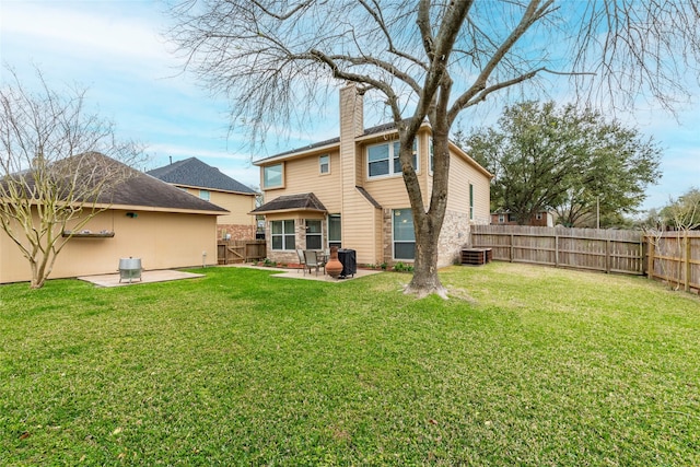 rear view of property with a patio, a fenced backyard, a lawn, and a chimney