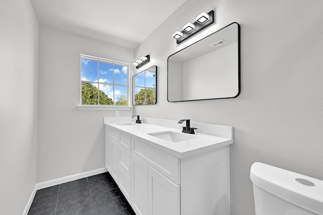 bathroom with a sink, visible vents, baseboards, and toilet