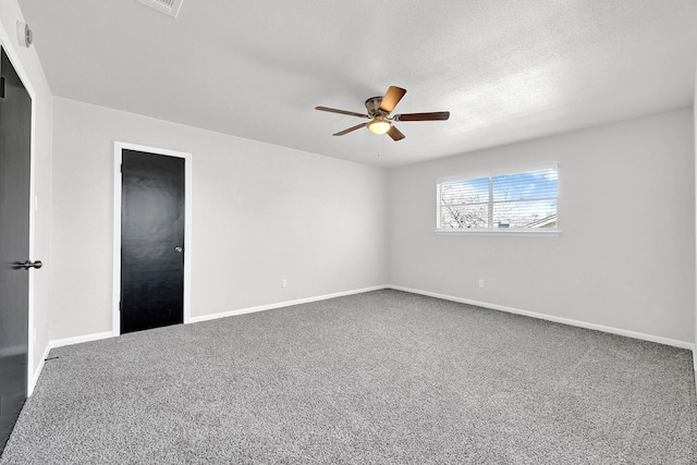 carpeted empty room with baseboards, a textured ceiling, and a ceiling fan