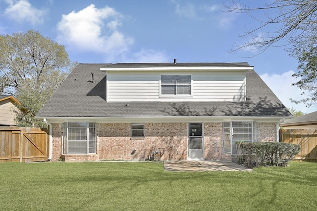 back of house featuring a yard, brick siding, and a patio