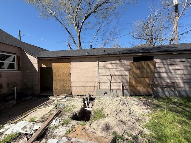 back of house with crawl space and a shingled roof