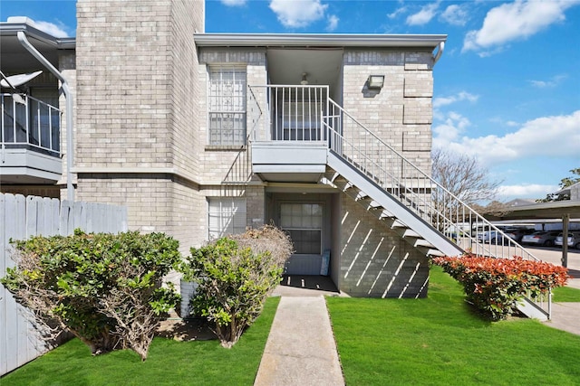 view of property featuring stairs and fence