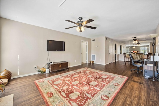 living room featuring visible vents, baseboards, and wood finished floors