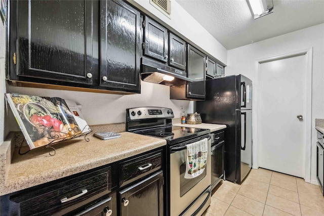 kitchen with under cabinet range hood, stainless steel electric stove, dark cabinets, and light tile patterned floors