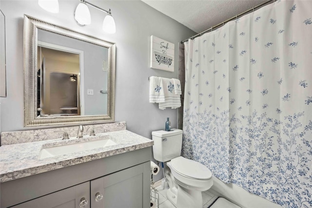 bathroom with a textured ceiling, toilet, and vanity