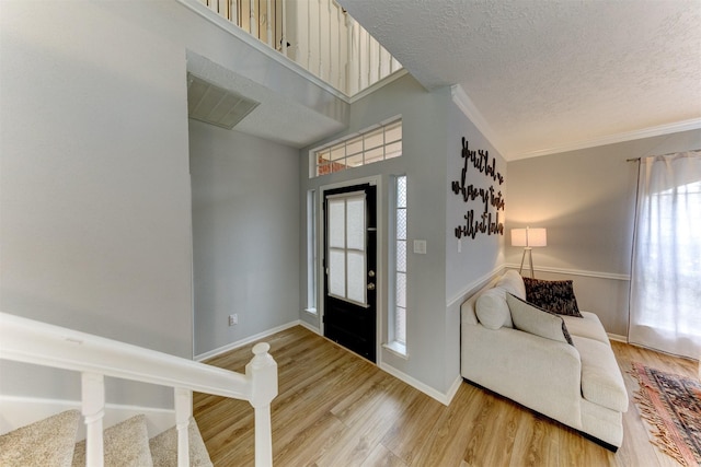 entryway with wood finished floors, baseboards, and a textured ceiling