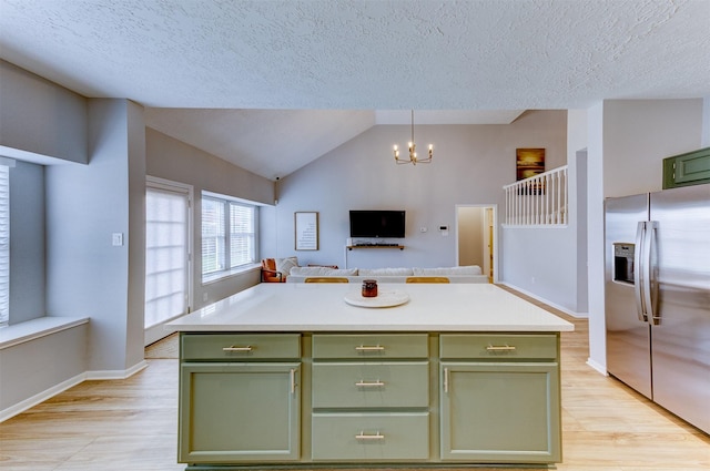 kitchen with light countertops, stainless steel refrigerator with ice dispenser, and green cabinetry