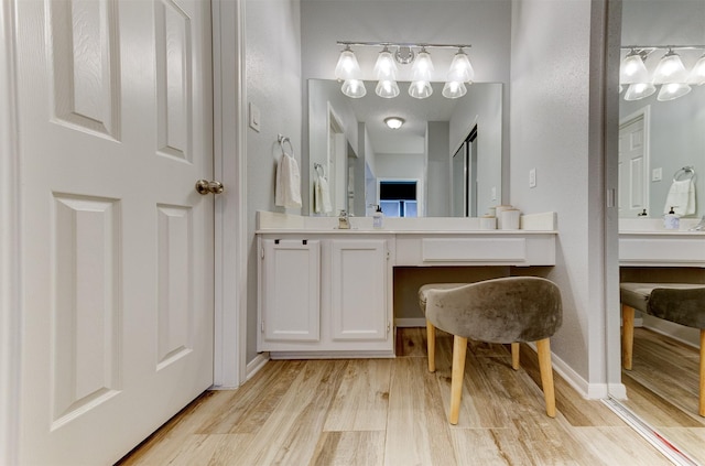 bathroom featuring vanity, baseboards, and wood finished floors