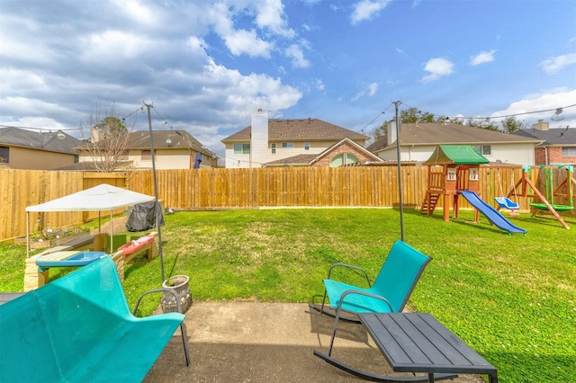 view of yard with a patio area, a playground, and a fenced backyard