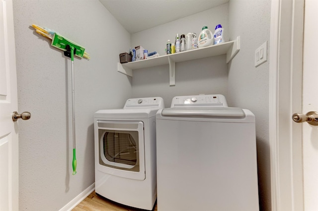 laundry room featuring laundry area, light wood-type flooring, and washer and clothes dryer