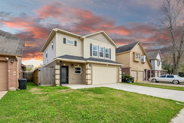 view of front of house featuring a front yard, fence, driveway, a garage, and brick siding