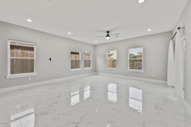 unfurnished living room with baseboards, recessed lighting, marble finish floor, and ceiling fan