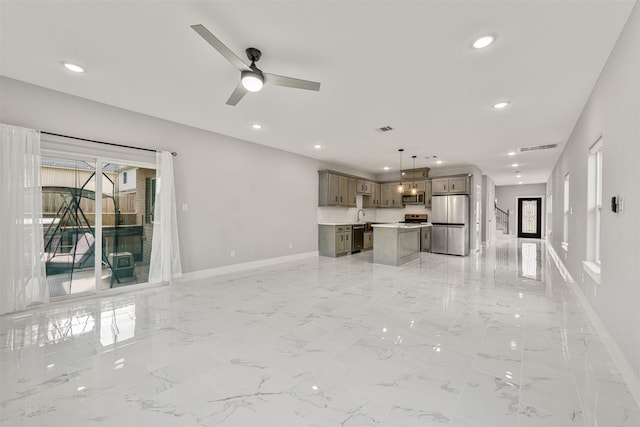 unfurnished living room with recessed lighting, visible vents, marble finish floor, and baseboards
