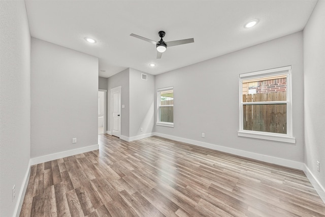 spare room featuring light wood-style flooring, recessed lighting, ceiling fan, and baseboards